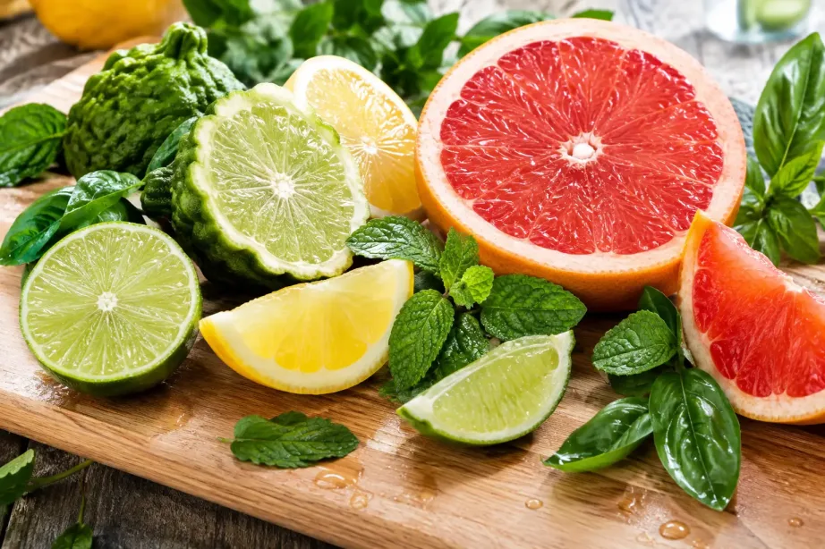 Pokrojone bergamotki, cytryny, grejpfruty i limonki ze świeżą miętą i bazylią na desce